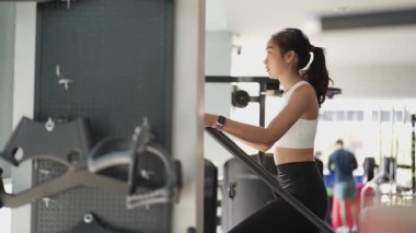 Asyalı kadınların spor salonunda egzersiz yaparken, sağlık ve sağlıklı bir yaşam tarzını desteklerken, eğitim, refah ve spor yaparken çekilmiş fotoğrafları..