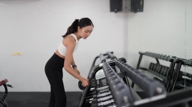 Asyalı kadınların spor salonunda egzersiz yaparken, sağlık ve sağlıklı bir yaşam tarzını desteklerken, eğitim, refah ve spor yaparken çekilmiş fotoğrafları..