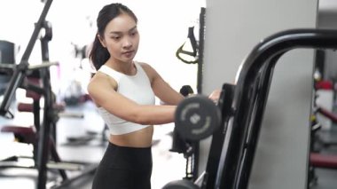 Asyalı kadınların spor salonunda egzersiz yaparken, sağlık ve sağlıklı bir yaşam tarzını desteklerken, eğitim, refah ve spor yaparken çekilmiş fotoğrafları..