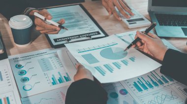 İş adamları, modern bir ofis işyerinde başarılı takım çalışması, takım çalışması, mali veri analizi, verimlilik ve planlama sonuçlarını gösteren çizelge ve grafikleri tartışıyor..