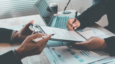 İş adamları, modern bir ofis işyerinde başarılı takım çalışması, takım çalışması, mali veri analizi, verimlilik ve planlama sonuçlarını gösteren çizelge ve grafikleri tartışıyor..