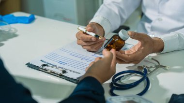 Masada oturan bir doktor ve hastanın yakın plan görüntüsü. Tıp ve sağlık hizmetleriyle ilgili kavramlar, doktor ve hasta.