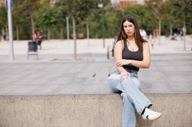 Güzel genç bir kadın Barcelona 'da yalnız başına oturuyor, günlük giysiler, kameraya bakıyor, rahat doğal bir gülümseme, hayat tarzı için mükemmel..