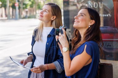 Gülümseyen gezginler haritadaki yönleri karşılaştırırken otobüsün geziye devam etmesini bekliyorlar..