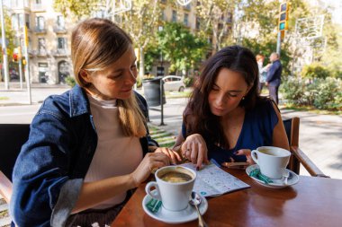 İki arkadaş şehir haritasına heyecanla bakıyor, yeni anıları keşfetmeye ve yakalamaya hazır..