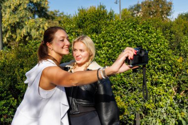 İki kadın sıcak ve keyifli bir park yürüyüşünden zevk alır. Klasik selfie çekerken doğal ve neşeli anları yakalar..
