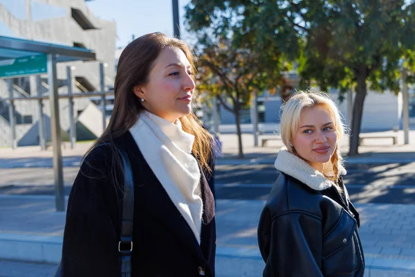 İki arkadaş tramvay istasyonunda oturmuş tramvaylarını beklerken rahat bir sohbetin tadını çıkarıyorlar.