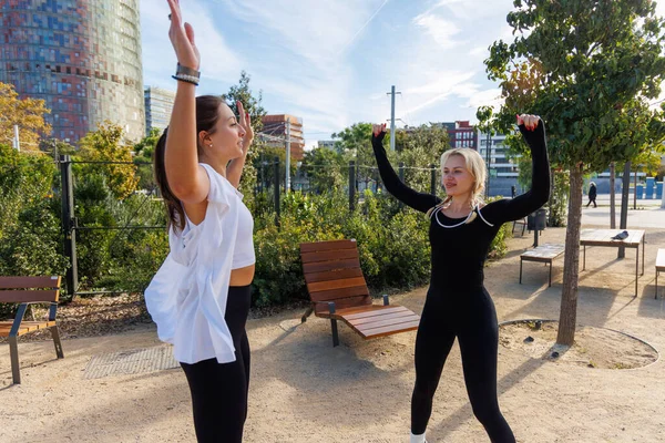 İki kadın direniş eğitimi için bantları kullanıyor. Parkta denge ve güç üzerine çalışıyorlar..