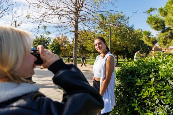 İki kadın sessiz bir parkta yürürler ve eski bir kamerayla eğlenceli fotoğraflar çekerler. Birlikte dışarıda eğlenirler.