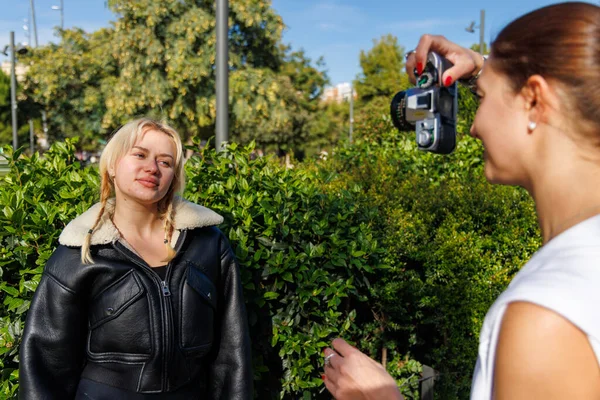 İki kadın parkta yürür ve ışık dolu neşeli bir açık hava anının tadını çıkarırlar..