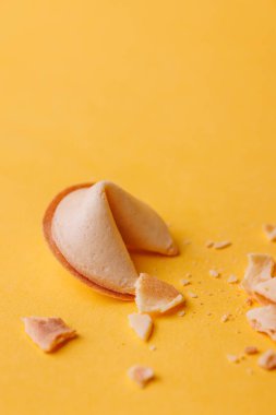 Parlak sarı arka planda otantik altın talih kurabiyeleri. Sert gölgeler bu geleneksel kutlama atıştırmalıklarının dokusunu vurgular....