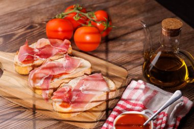 Sağlıklı Akdeniz diyeti. Köy tahtasında pişmiş jambon ve ekstra saf zeytinyağı. İspanyol gastronomisi ve menüleri için yüksek kaliteli görüntüler.