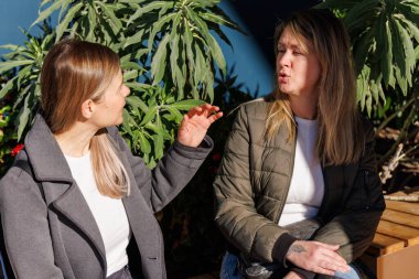 En iyi arkadaşlar alışveriş merkezinin girişinde bir anı paylaşırlar. Sosyal medyada gezinmek için akıllı telefon kullanıyorlar ve alışveriş gezilerine ara verdiklerinde mutlu bir şekilde sohbet ediyorlar..