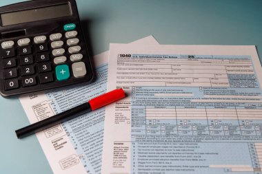 15 Nisan Gelir Vergisi Formu 1040 ve masa gereçleri konsepti. Finansal danışmanlar, muhasebe ve vergi hazırlama hizmetleri için güneşli masa görünümü.