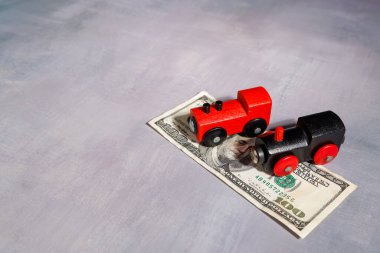 Oyuncak tren para basıyor. Taşınma, ulaşım yoksulluğu ve küresel kentsel seyahat sistemlerindeki mali uçurumu temsil etmek için ideal.