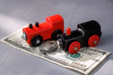 Nakit parayla dolu bir oyuncak trenle yüksek seyahat maliyeti. Seyahat borçlarını, ulaşımı, yoksulluğu ve ulaşılamaz ulaşım sistemlerini göstermek için mükemmel..