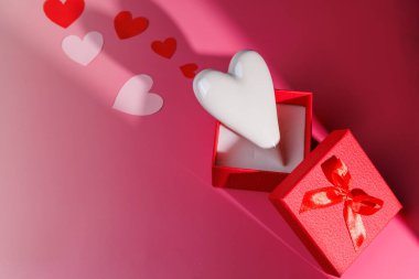 Pembe hediye kutusunda seramik kalpler. Çiftler için ideal aşk, romantik yıldönümleri ve dijital pazarlama reklamları için temiz tatil tasarımları..