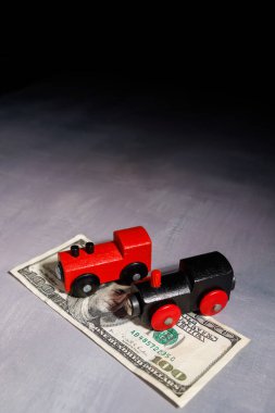 Nakit parayla dolu bir oyuncak trenle yüksek seyahat maliyeti. Seyahat borçlarını, ulaşımı, yoksulluğu ve ulaşılamaz ulaşım sistemlerini göstermek için mükemmel..