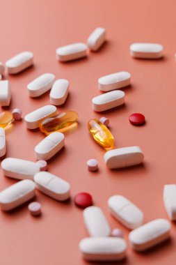 Krem rengi arka planda birden fazla hap ve kapsül var. Metabolik sağlık, vitamin takviyeleri ve profesyonel tıbbi tedaviler için yüksek kaliteli görüntü.