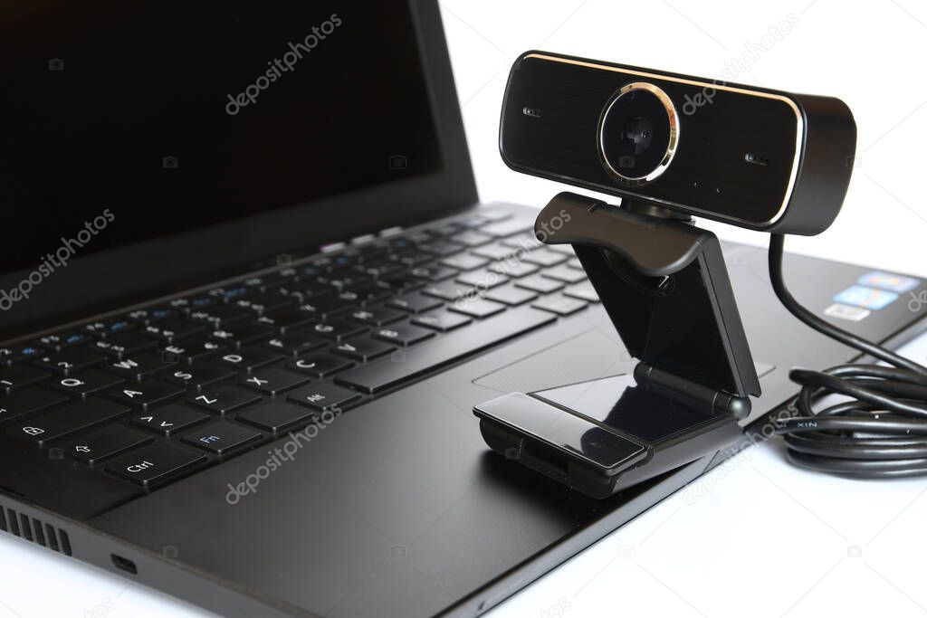 Black computer webcam on notebook keyboard.