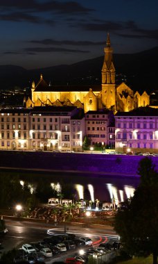 Floransa, Temmuz 2021: Turistler, yaz mevsiminde Floransa 'daki ünlü Kutsal Haç Bazilikası önünde Arno Nehri kıyısındaki gece kulüplerinde dinleniyorlar..