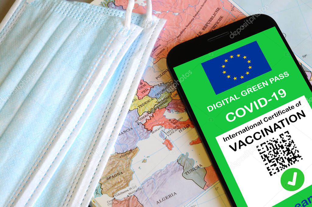 The digital green pass of the European Union with the QR code on the screen of a smartphone. Covid or Coronavirus vaccine certificate, with mask and map of Europe