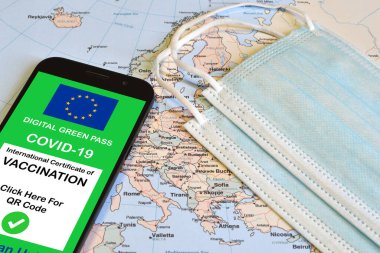 Avrupa Birliği 'nin akıllı telefonlar ve coğrafi haritadaki cerrahi maskelerle birlikte dijital yeşil geçiş kartı. Coronavirus ve Yeşil Geçiş sırasında güvenli seyahat konsepti