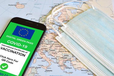 Avrupa Birliği 'nin akıllı telefonlar ve coğrafi haritadaki cerrahi maskelerle birlikte dijital yeşil geçiş kartı. Coronavirus ve Yeşil Geçiş sırasında güvenli seyahat konsepti