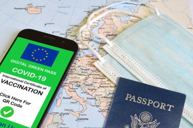 Avrupa Birliği 'nin, ameliyat maskesi ve pasaport takılı haritalar üzerinde akıllı telefonun ekranında QR kodu olan dijital yeşil geçiş kartı. Covid-19 'dan dokunulmazlık. Kısıtsız seyahat et.