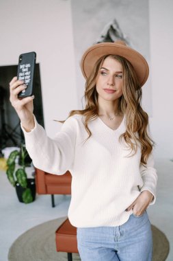 Şapkalı güzel sarışın kız selfie çekiyor.