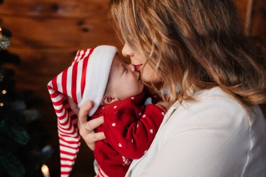 Annem yeni yıl elbisesi içinde yeni doğmuş bir bebeği öpüyor.