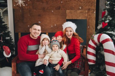 İki kız ve erkek kardeş Noel ağacının yanında sarılıyor. Noel Baba 'yı bekliyorum. hediyeleri açın. Büyük aile..