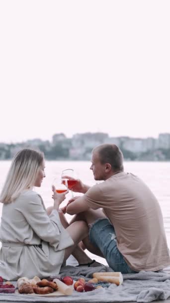 Amante pareja bebiendo vino de vasos en el lago — Vídeos de Stock