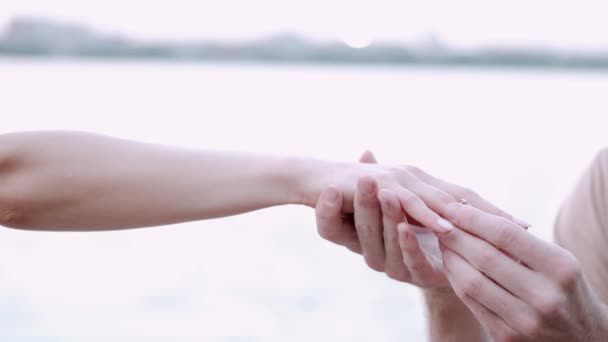 Jongeren handen zetten aanzoek ring om vrouwen vinger aan het meer — Stockvideo