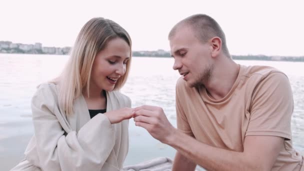 Joven haciendo proposición a una mujer en el lago — Vídeo de stock