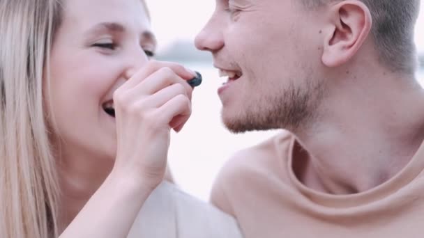 Young couple are eating on the lake background — Stock Video