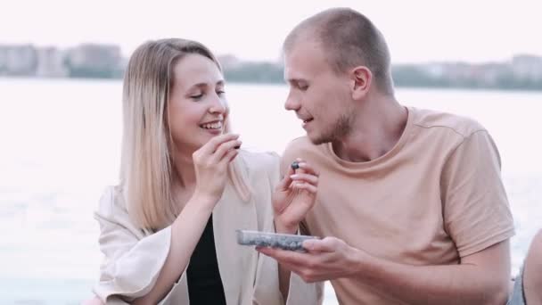 Pareja joven está comiendo en el fondo del lago — Vídeos de Stock