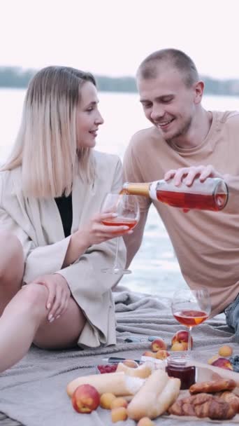 Fidanzato e fidanzata sono su un picnic seduti su una banchina di legno al lago — Video Stock