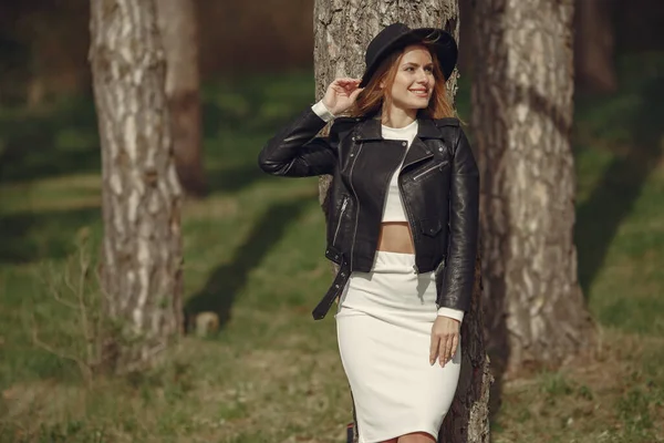 Mulher elegante em um chapéu preto em uma floresta de primavera — Fotografia de Stock