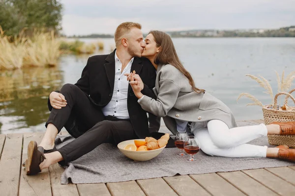 Les gens assis au bord de l'eau avec ensemble de pique-nique — Photo