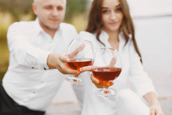 Gente sentada junto al agua con juego de picnic — Foto de Stock