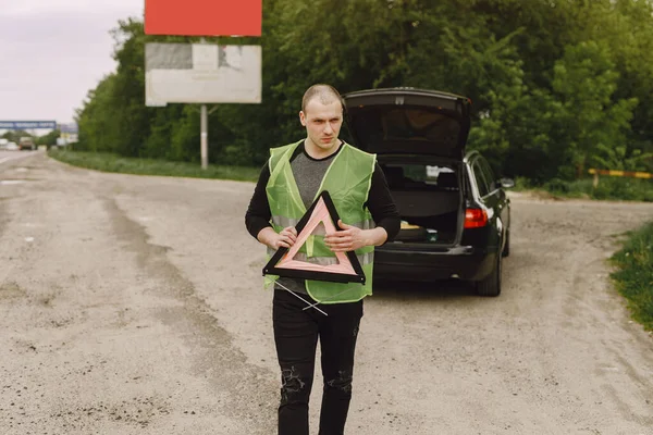 Auto s problémy a červený trojúhelník varovat ostatní účastníky silničního provozu — Stock fotografie