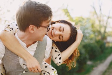 Genç bir adam ve kadın çiçek açan bir bahçede.