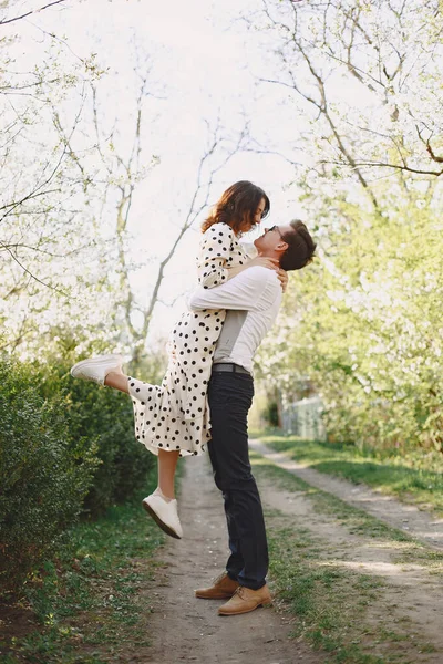 Молодой человек и женщина пара в цветущем саду — стоковое фото