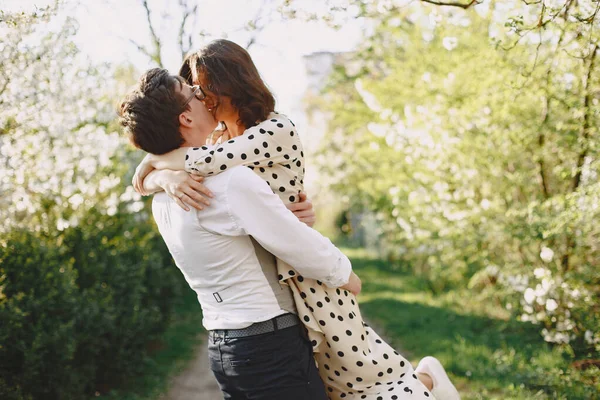 Fiatal férfi és nő pár egy virágzó kertben — Stock Fotó