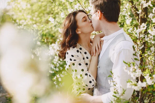 Young man and woman couple in a blooming garden — Stock Photo, Image