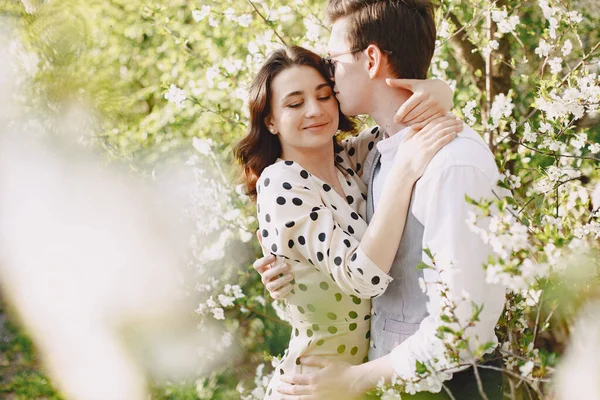 Mladý muž a žena pár v kvetoucí zahradě — Stock fotografie