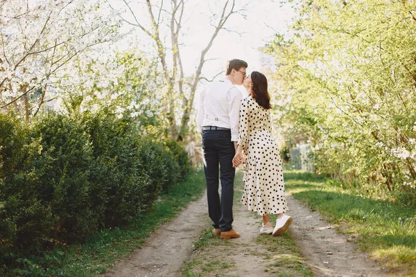 Młody mężczyzna i kobieta para w kwitnącym ogrodzie — Zdjęcie stockowe
