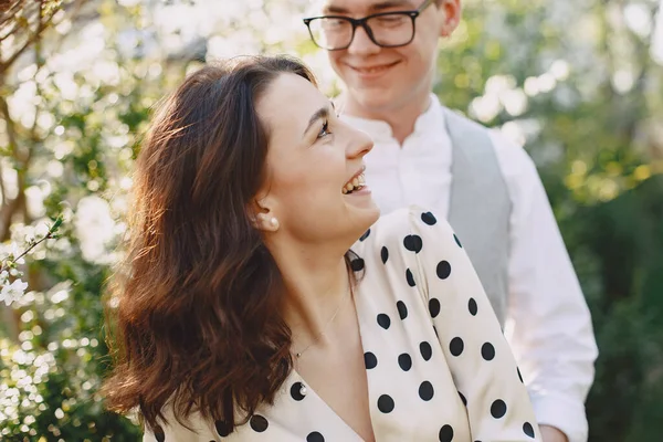 Fiatal férfi és nő pár egy virágzó kertben — Stock Fotó