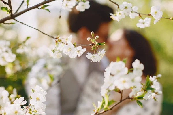 Young man and woman couple in a blooming garden — Stock Photo, Image